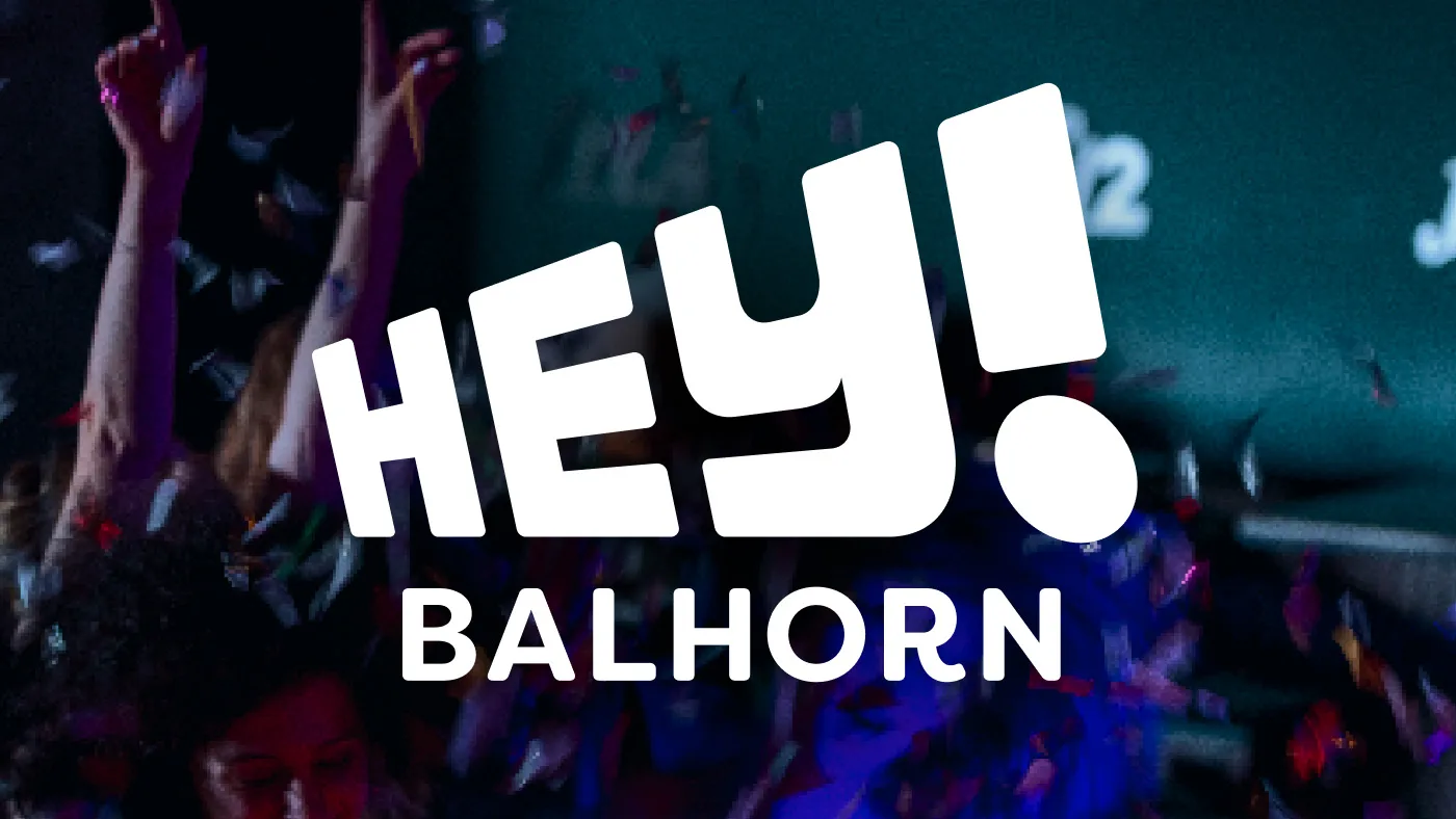 Junge Menschen feiern auf einer Party mit Konfetti und dem Schriftzug "HEY! BALHORN" in Weiß.